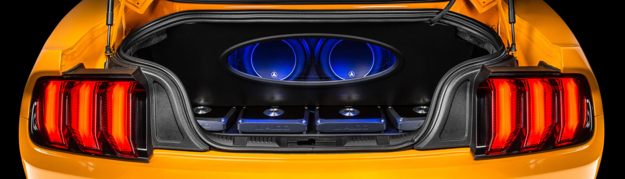 Orange Mustang with illuminated JL Audio trunk installation